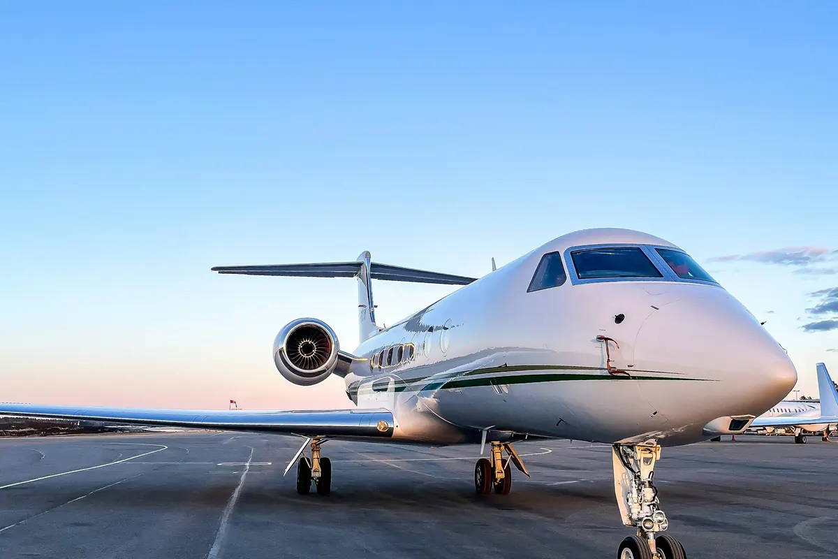 Business jet parked on the ramp under a clear sky