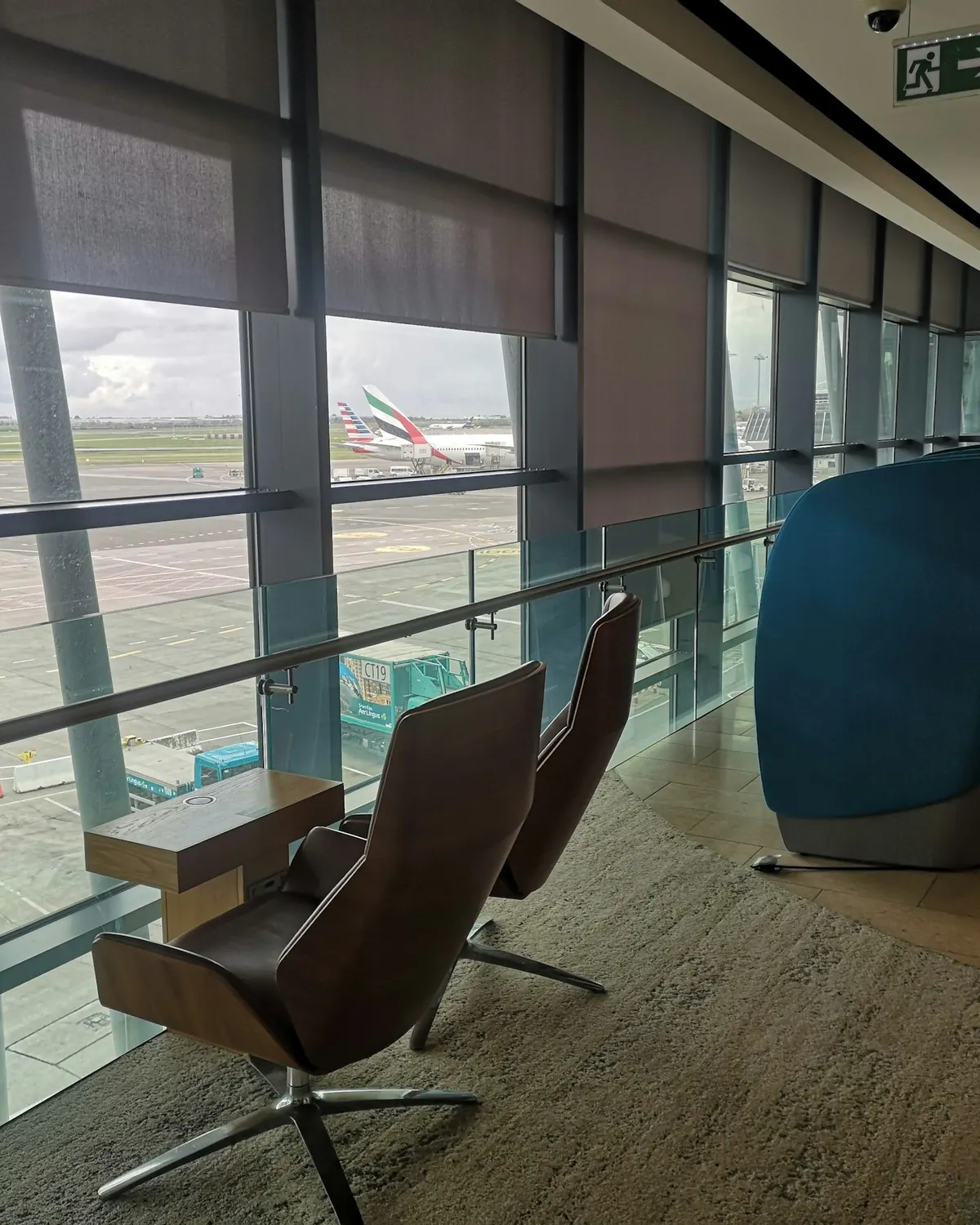 Airport lounge with leather armchairs facing a window over the apron